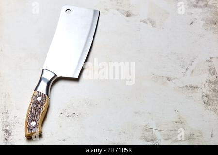 Fleischspalter auf Holzhintergrund. Küchenmesser oder Metzgerspalter aus Edelstahl auf einer Holzplatte Stockfoto
