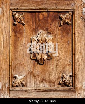 Nahaufnahme von Details der alten Holztür mit geschnitzten Blumen und Holzstruktur Stockfoto