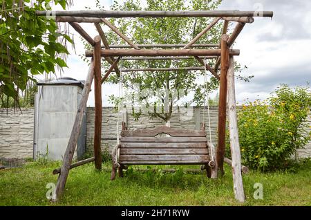 Holzschaukel im Garten. Schaukel zum Entspannen im Vorstadthof Stockfoto