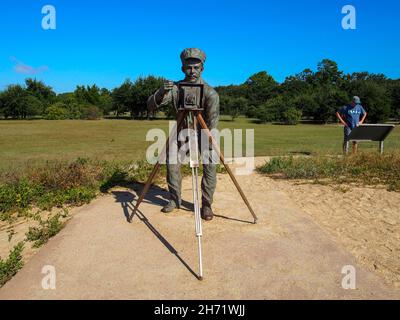 Fotograf John T. Daniels Teil der Bronzeskulptur vom 17. Dezember 1903 von Stephen H. Smith am Wright Brothers National Memorial mit Tourist Stockfoto