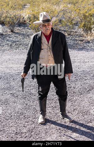 Der Cowboy-Führer mit seinem alten schwarzen Pulversechs-Shooter in der alten Geisterstadt Shakespeare, New Mexico. Stockfoto