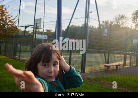 Junges Mädchen, das an einem Seil hängt und mit der Hand neben der Kamera mit Kopierraum spielt Stockfoto