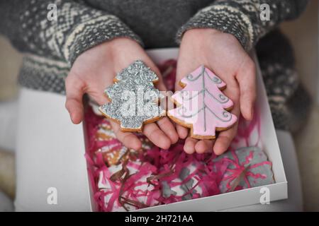 Lebkuchen in Form eines Weihnachtsbaums in den Händen eines Mädchens. Stockfoto