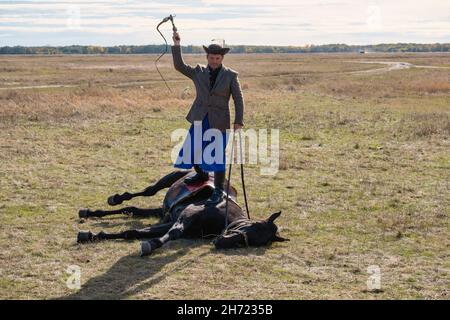 Ein ungarischer Csiko legt sich ein Pferd auf seine Schulter, in der Puszta, Hortobagy Nationalpark, Ungarn Stockfoto