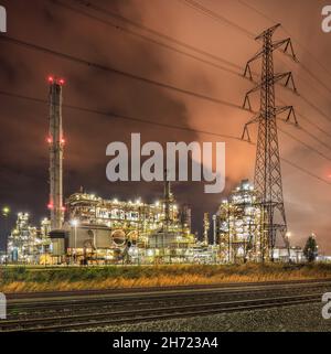Nachtszene mit großer beleuchteter petrochemischer Produktionsanlage im Hafen von Antwerpen. Stockfoto