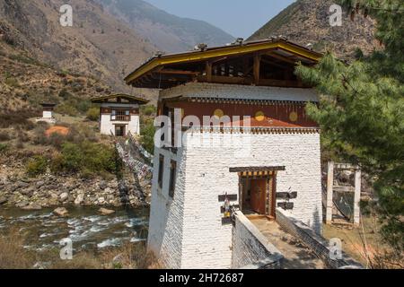 Gebetsfahnen säumen die letzte verbliebene eiserne Kettenbrücke in Bhutan über den Paro Chhu Fluss in der Nähe von Paro, Bhutan. Stockfoto