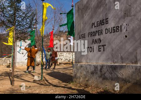 Ein bhutanesischer Bogenschütze konkurriert mit einem zusammengesetzten Bogen in einem Bogenschießwettbewerb in Paro, Bhutan. Stockfoto