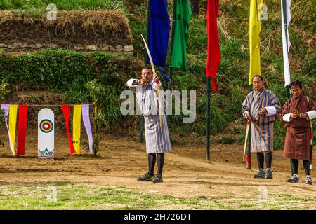 Ein bhutanesischer Bogenschütze konkurriert bei einem Bogenschießwettbewerb in Thimphu, Bhutan, mit einem rekurvten Bogen. Stockfoto