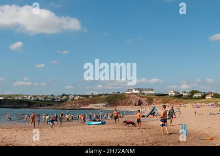 Strandbesucher genießen das sonnige Wetter und den blauen Himmel am South Milton Sand Beach, Devon, Großbritannien Stockfoto