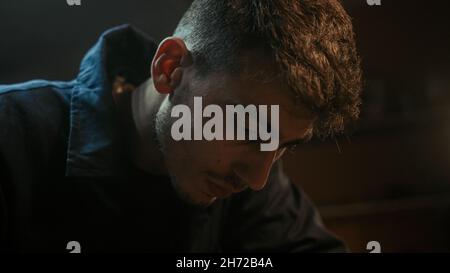 Nahaufnahme eines jungen Schmieds, der mit Schleifstab Schleifpapier macht Stockfoto