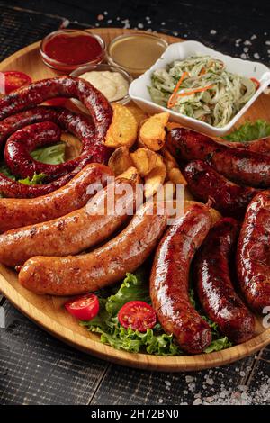 Verschiedene Grillwürste auf Holzbrett Stockfoto