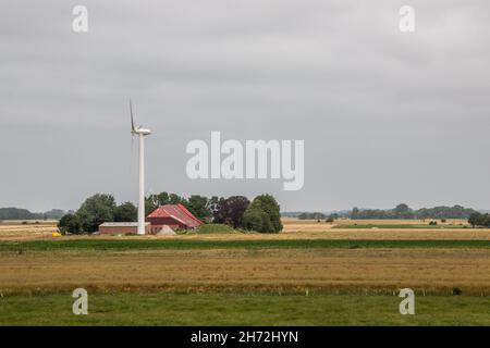 Windräder für erneuerbare Energie auf dem flachen Marschland Norddeutschlands Stockfoto