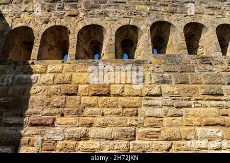 Fenster in den massiven hohen Mauern einer alten mittelalterlichen Burg Stockfoto