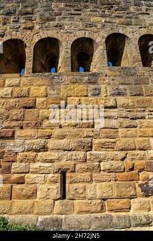 Fenster in den massiven hohen Mauern einer alten mittelalterlichen Burg Stockfoto