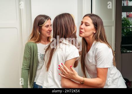 Lächelnder Zahnarzt, der eine Mutter und Tochter in seinem Büro zur Behandlung empfängt. Konzept Zahnpflege, Gesundheitswesen. Stockfoto