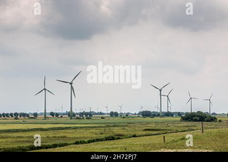 Windräder für erneuerbare Energie auf dem flachen Marschland Norddeutschlands Stockfoto