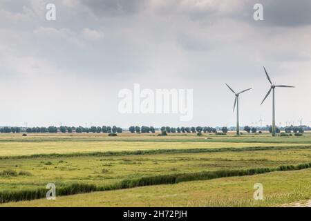 Windräder für erneuerbare Energie auf dem flachen Marschland Norddeutschlands Stockfoto