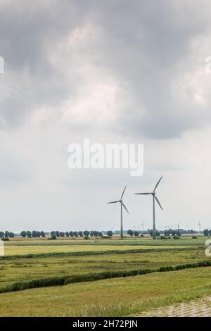 Windräder für erneuerbare Energie auf dem flachen Marschland Norddeutschlands Stockfoto