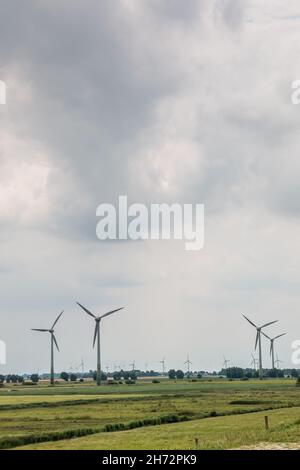 Windräder für erneuerbare Energie auf dem flachen Marschland Norddeutschlands Stockfoto