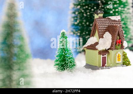 Spielzeughaus im Schnee, Neujahrskarte. Platz kopieren, Konzept Stockfoto