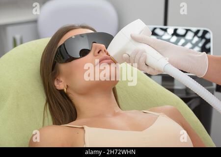 Kosmetologie. Nahaufnahme der Hände der Kosmetikerin, die im Spa-Salon Schönheitsbehandlungen für das weibliche Gesicht machen. Gesichtsbehandlung Stockfoto