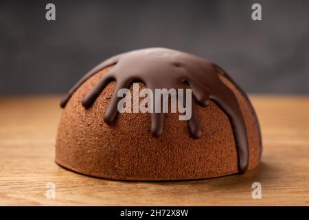 Französischer Mousse-Kuchen mit Schokoladenglasur auf Holzboden bedeckt. Stockfoto