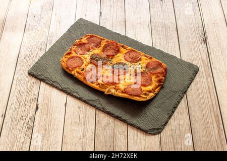 Pepperoni ist eine amerikanische Sorte von Salami, die aus gehärtetem Schweinefleisch und Rindfleisch hergestellt wird, gemischt und gewürzt mit Paprika oder anderen Chilischoten, die charakteristisch mild und lig sind Stockfoto