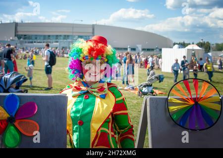 23. August 2015, Kolomna, Region Moskau. Mädchen in einem hellen Bild eines Clowns auf einer Stadtstraße. Emotionales Porträt eines Studenten. Kostümierte Präsentation von Stockfoto