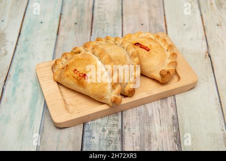 Argentinische Empanadas, gefüllt mit kreolischem Eintopf auf Holzplatte Stockfoto