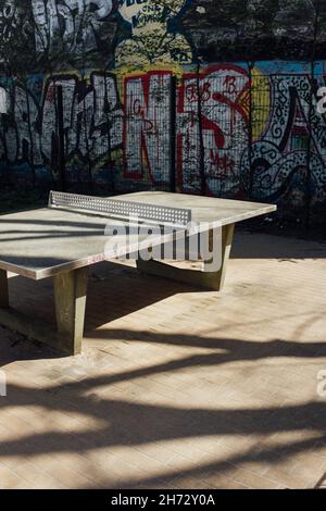 Schöne Aussicht auf eine Tischtennisplatte und eine Graffiti-Wand im Park Stockfoto