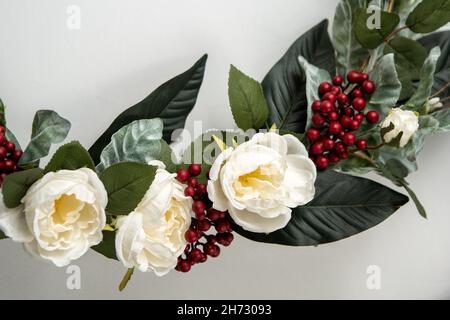 Nahaufnahme von Blumen und Preiselbeeren auf dem Weihnachtskranz Stockfoto