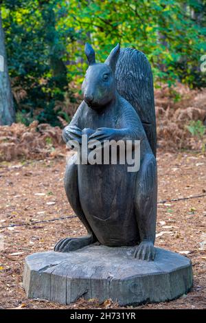 Statue Holzschnitzerei des Eichhörnchens in sandringham in norfolk, Eichhörnenskulptur, Holzschnitzerei eines roten Eichhörnchens auf dem Gelände von sandringham norfolk Stockfoto