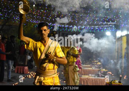 Howrah, Indien. 19th. November 2021. Ganga Aarti, das Opfergebet an den Ganges, wird täglich am Abend im Winter in Ramkrishnapur Ghat, Howrah, abgehalten. Priester führen dieses Ritual durch, indem sie diya tragen und es in einer rhythmischen Melodie von bhajan auf dem glückverheißenden Tag von Kartik Purnima nach oben und unten bewegen, das bhakti zu Herrn Vishnu bedeutet. (Foto von Biswarup Ganguly/Pacific Press) Quelle: Pacific Press Media Production Corp./Alamy Live News Stockfoto