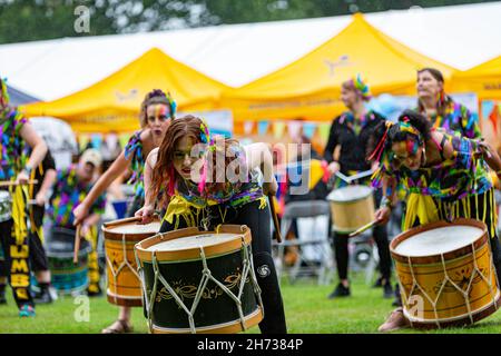 Katumba-Trommler unterhalten sich im Regen beim 30-jährigen Jubiläum des Behindertenbewusstseins in Walton Hall and Gardens, cheshire Stockfoto