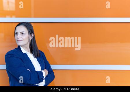 Schöne kaukasische Geschäftsfrau mit gekreuzten Armen auf der Strome Stockfoto
