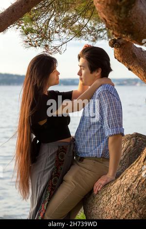 Gutaussehendes junges biracial asiatisch kaukasisch gemischtes Rassenpaar genießen Zeit zusammen am See bei Sonnenuntergang im Pazifischen Nordwesten Stockfoto