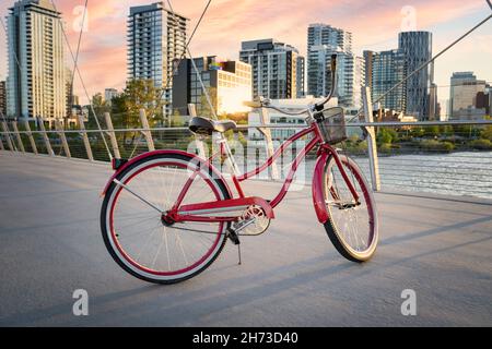 Calgary, Alberta, Kanada, 10 2021. Juli: Ein Huffy Cruiser-Fahrrad parkte bei Sonnenuntergang auf einem Brückenweg in der Innenstadt. Stockfoto