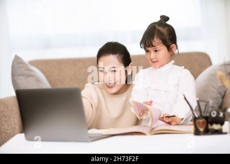 Mutter führt Tochter online lernen Stockfoto