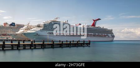 Cozumel, Mexiko - 31. Dezember 2019: Low-Angle-Panoramaaufnahme von Carnival Freedom, angedockt in Cozumel. Herrliches, glattes türkisfarbenes Wasser, hölzerner Pier in t Stockfoto