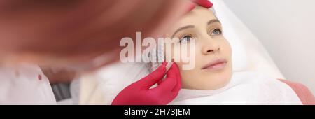 Kosmetikerin macht dauerhafte Make-up für Augenlider und Augenbrauen Frau Client im Schönheitssalon Stockfoto