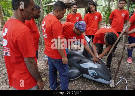 Freiwillige üben die Technik des Umgangs mit einem gestrandeten Meeressäuger-Dummy während einer Trainingseinheit zur Rettung von Meeressäugern.World Wide Fund for Nature (WWF) Indonesien und lokale Autorisierungen organisierten eine Trainingseinheit für Stranded Marine Mammals Handling Techniques für den 'First Responder' am Maimol Beach, Alor. „First Responder“ ist der Begriff für diejenigen, die in der Lage sind, schnell zu reagieren und Strandsäugetiere zu retten und einen Bericht für eine weitere Vorbehandlung zu erstellen. Nach Angaben der Datenbank des WWF Indonesien gibt es seit 2017 31 gestrandete Fälle sowohl für einzelne als auch für Gruppen marine m Stockfoto