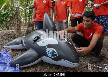 Freiwillige üben die Technik des Umgangs mit einem gestrandeten Meeressäuger-Dummy während einer Trainingseinheit zur Rettung von Meeressäugern.World Wide Fund for Nature (WWF) Indonesien und lokale Autorisierungen organisierten eine Trainingseinheit für Stranded Marine Mammals Handling Techniques für den 'First Responder' am Maimol Beach, Alor. „First Responder“ ist der Begriff für diejenigen, die in der Lage sind, schnell zu reagieren und Strandsäugetiere zu retten und einen Bericht für eine weitere Vorbehandlung zu erstellen. Nach Angaben der Datenbank des WWF Indonesien gibt es seit 2017 31 gestrandete Fälle sowohl für einzelne als auch für Gruppen marine m Stockfoto