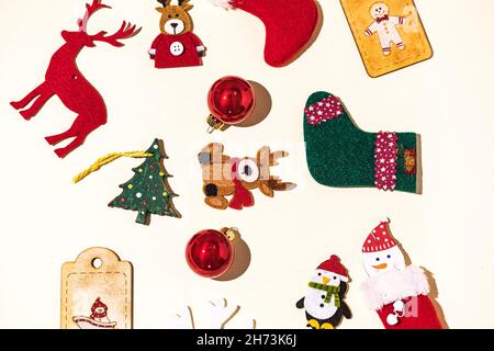 Weihnachten Stillleben mit Rentieren, Lebkuchenmann, Socken, weihnachtsmann und weihnachtsball, Schneeflocke und Pinguin Dekorationen auf pastellfarbenem Hintergrund. Ch Stockfoto