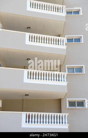 Mehrstöckige, moderne Wohnungart-Gebäude in Nahaufnahme, Fassadenteil mit vielen Balkonen im Schatten. Stockfoto