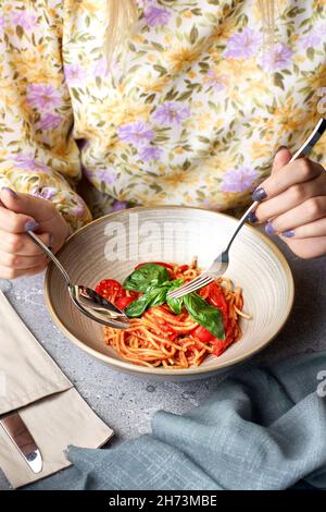 Mädchen isst gesunde Lebensmittel, Vegetarisch appetitliche Pasta mit Tomatensauce Stockfoto