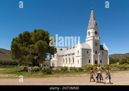 Kinder gehen an der holländischen reformierten Kirche, Nieu Bethesda, Eastern Cape Province, Südafrika, 06. Januar 2011 vorbei. Stockfoto