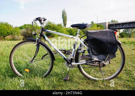 POZNAN, POLEN - 09. Mai 2015: Eine schöne Aufnahme eines Fahrrads mit Reisetasche auf einem Grasfeld in Poznan, Polen Stockfoto