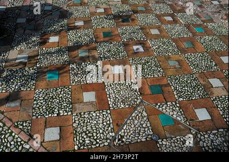 Weiße Flusskiesel, warme Terrakotta- und türkisfarbene Fliesen: Ein Bürgersteig, der sich für einen Sultanssommer in den Gärten des Generalife in Granada, Andalusien, Spanien eignet Stockfoto