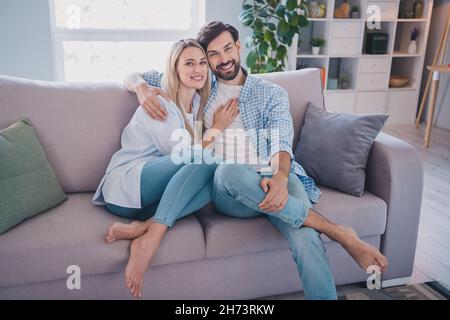 Foto von schönen verheirateten Paar gute Laune Umarmung sitzen Divan Wohnung selbst-Isolation Wochenende Romantik Beziehung drinnen Stockfoto