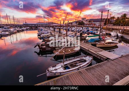 Ferrol, Spanien. 9. November 2021. Dramatischer Sonnenuntergang über dem alten Hafen von Ferrol. Kleine Angel- und Freizeitboote, die an Docks festgemacht sind. Galicien, Spanien Stockfoto